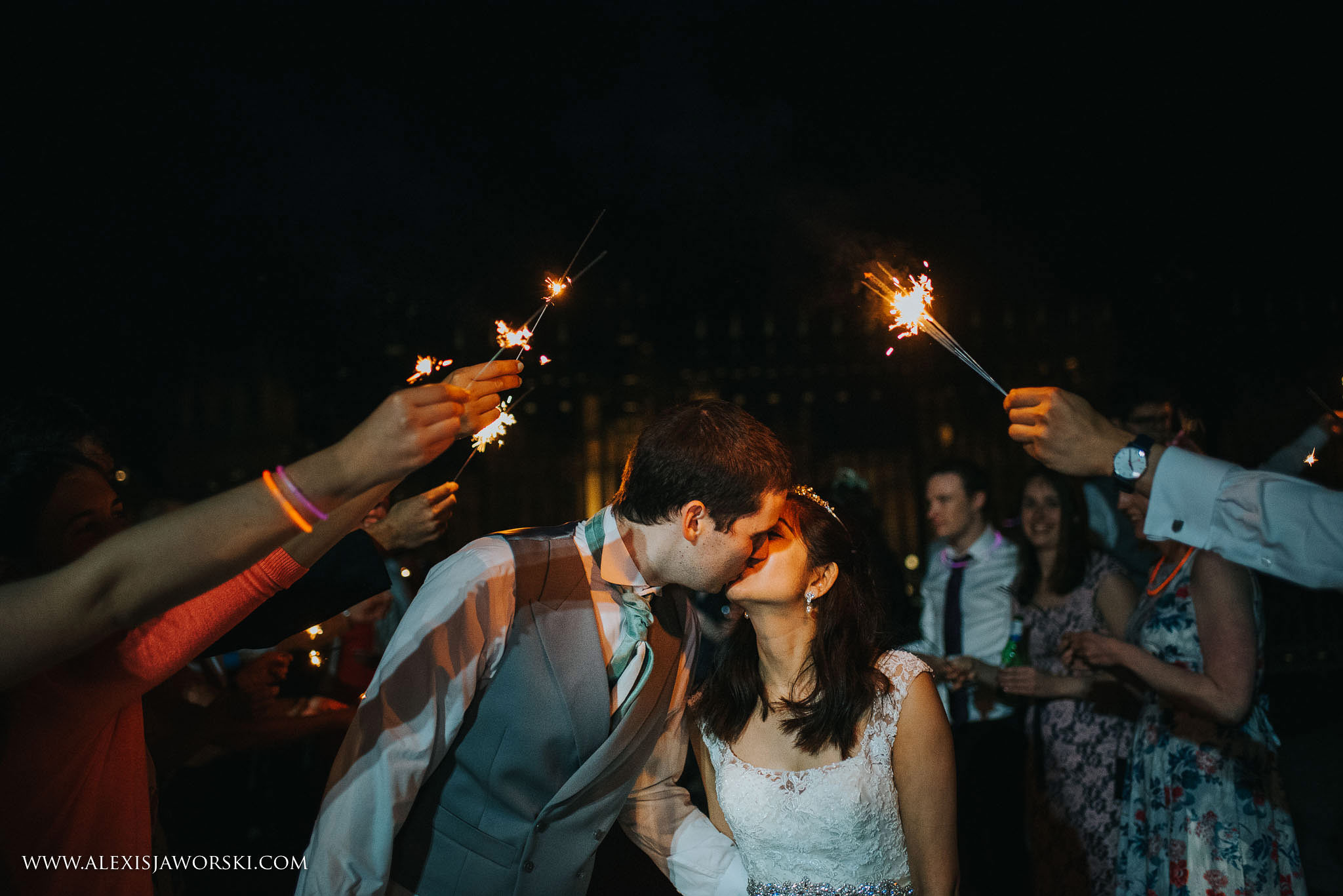 Bride and groom kiss through spraklers