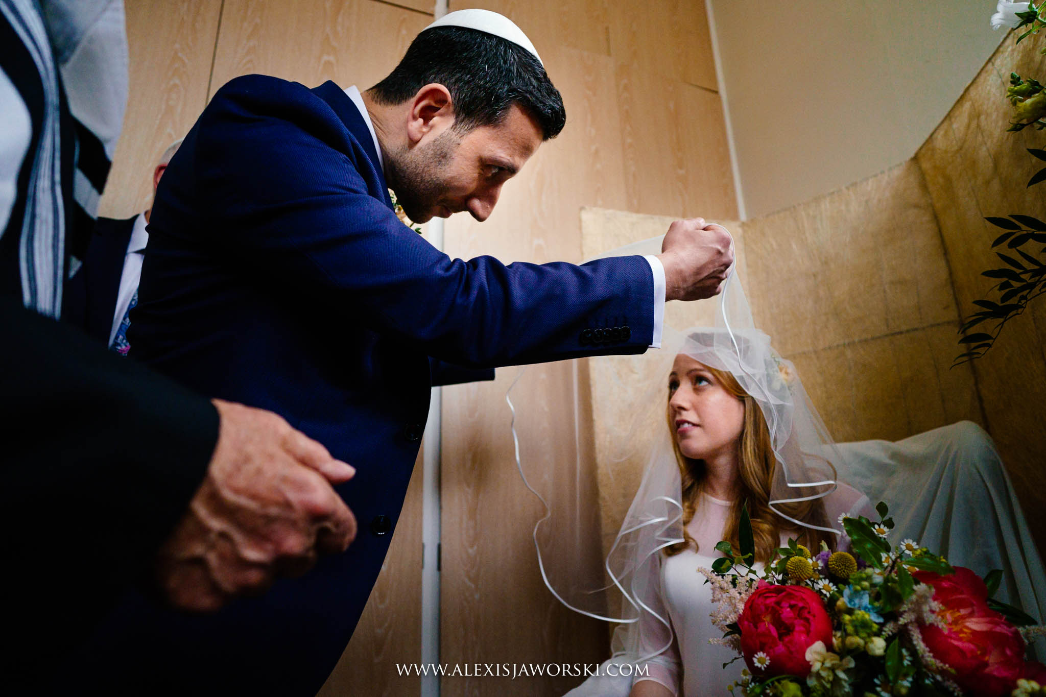 Groom lifting bride's veil